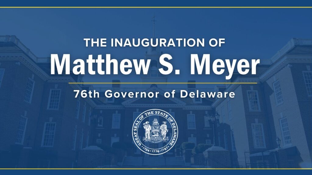 Delaware State Capitol building behind a blue film/screen with state logo on bottom with captions - The Inauguration of Matthew S. Meyer, 76th Governor of Delaware